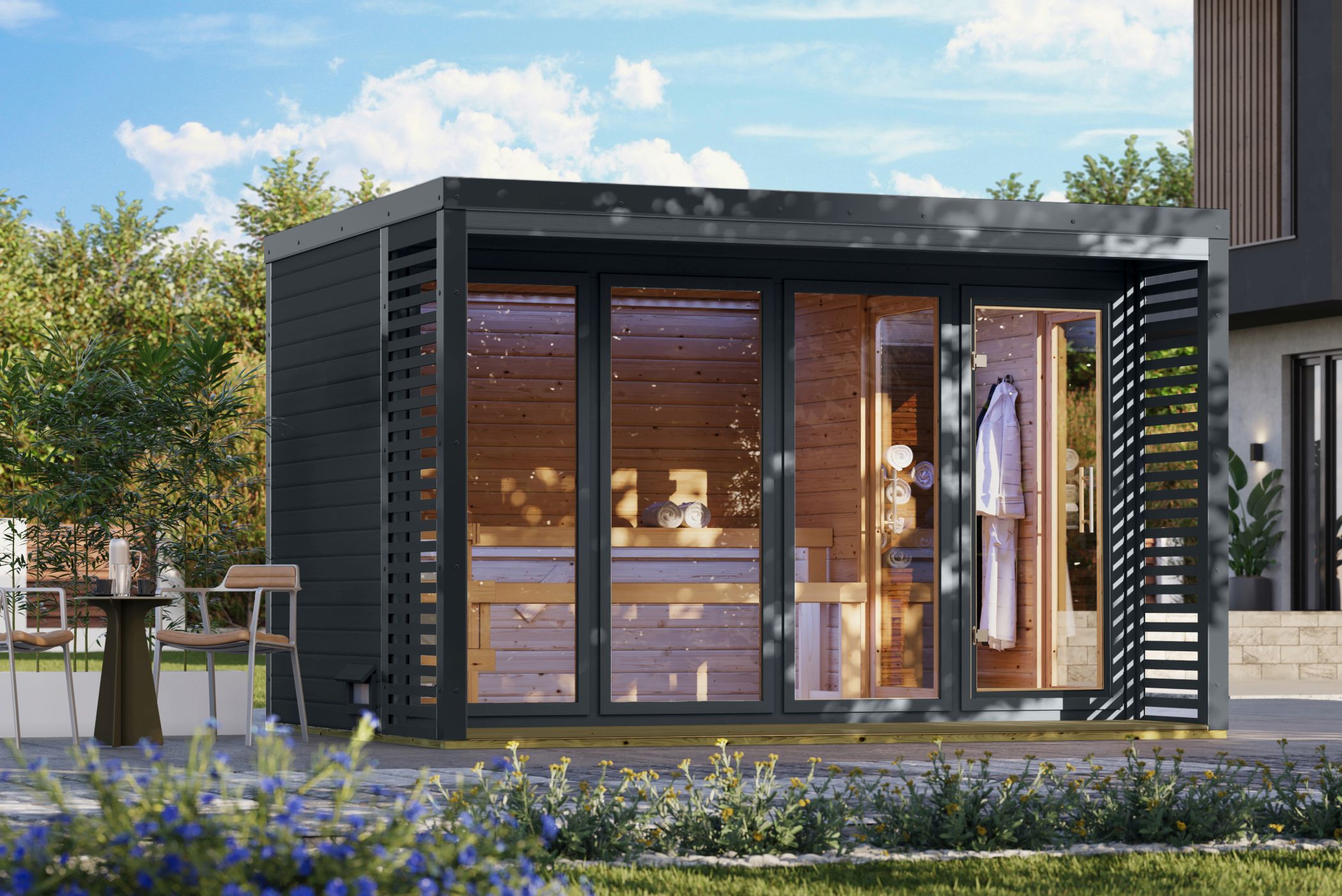 Karibu Saunahaus Ares 4 als Gartensauna aus Massivholz im Garten mit Glasfront