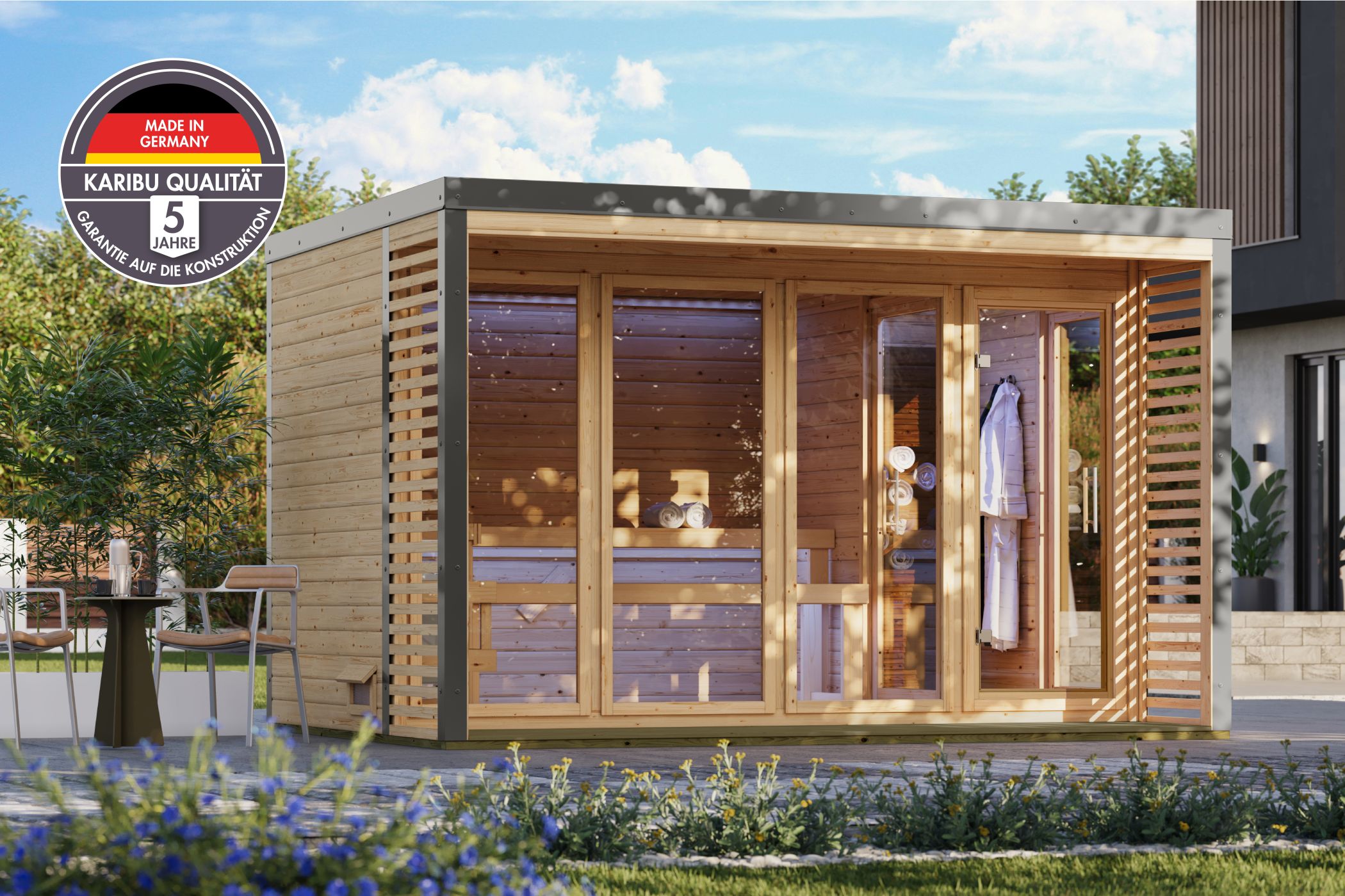 Karibu Saunahaus Ares 4 als Gartensauna aus Massivholz im Garten mit Glasfront